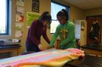 Two girls cutting fabric