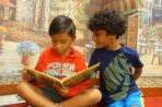 Two boys reading a book